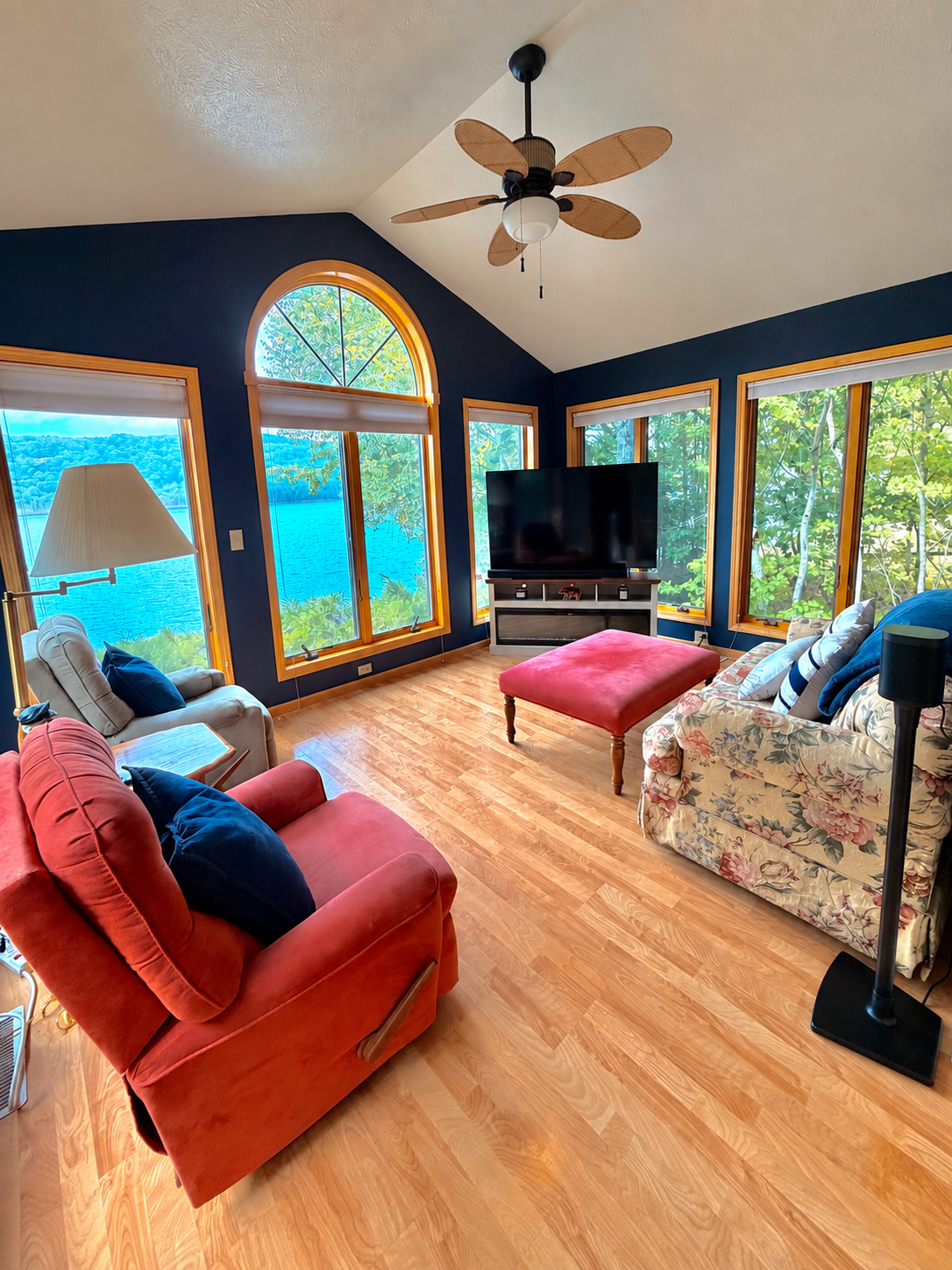 Second living room with arched window, lake views, television and colorful seating